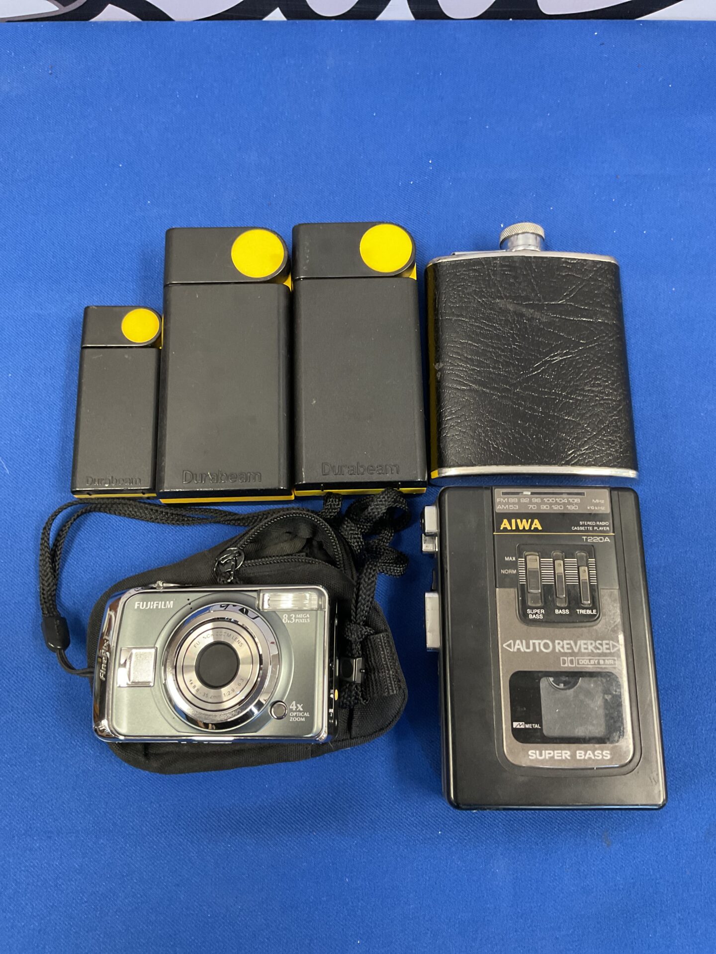 136 Box of mixed electricals including Fujifilm finepix digital camera, aiwa t220 Walkman with radio, various torches and hip flask