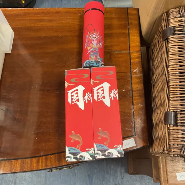 Three red ceramic flasks with detailed designs, collectible Asian decor.