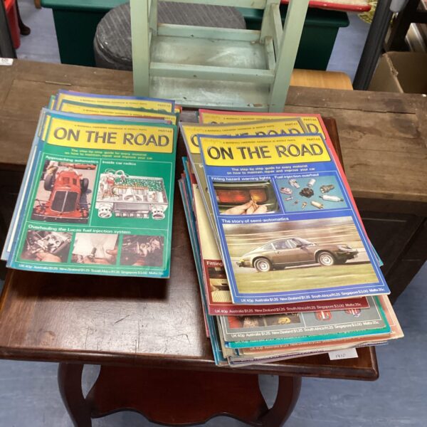 Stack of vintage road books for classic car maintenance and travel.