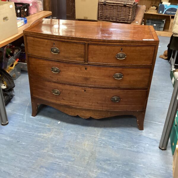 Antique chest of drawers with inlaid detailing and curved front.