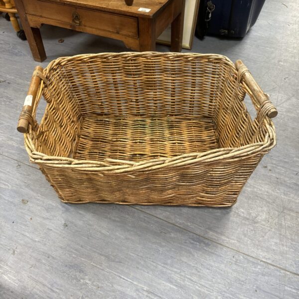 Large handled wicker log basket for firewood storage.