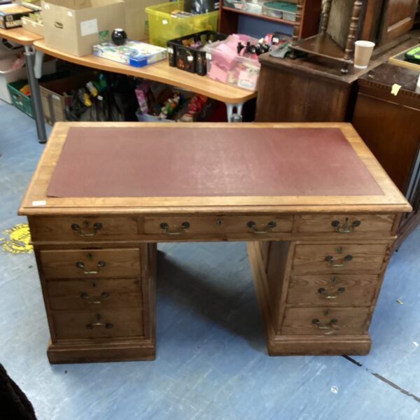 Antique executive pedestal desk with leather top and drawers.