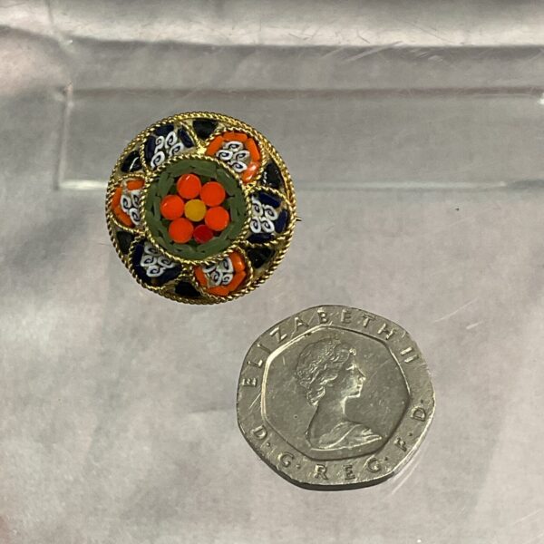 Close-up of a vintage Italian millifiori brooch with floral design.