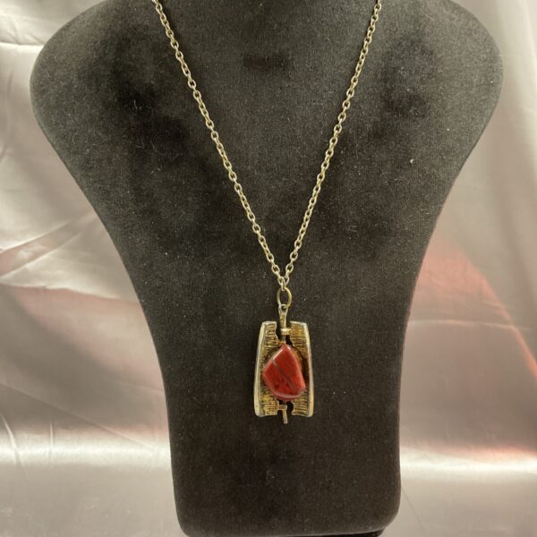 Vintage red jasper pendant necklace with textured brass setting.