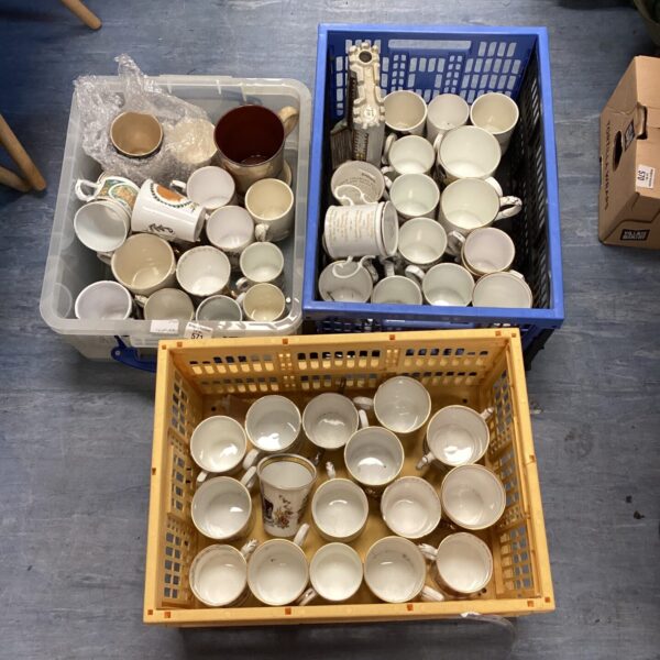 Three crates filled with a variety of royal commemorative mugs.
