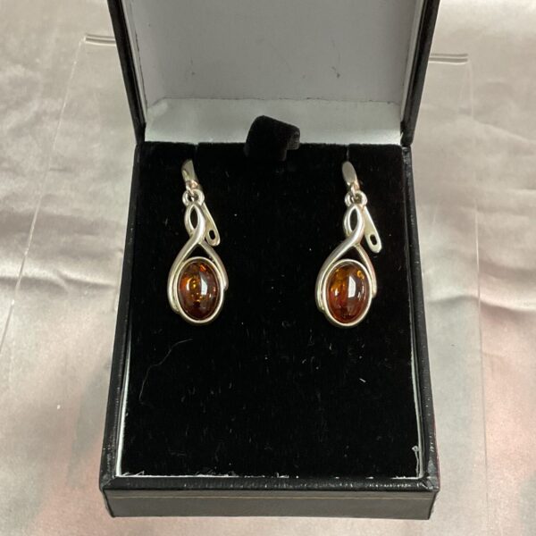 Silver Celtic earrings with amber teardrop stones.