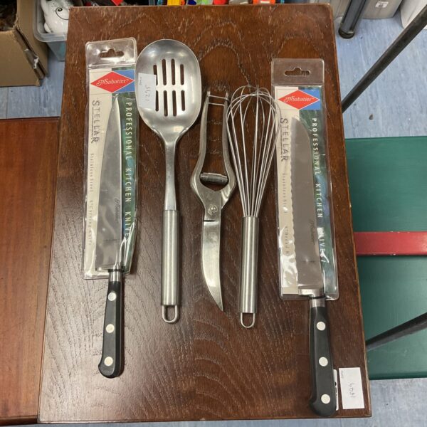Stainless steel kitchen knife set with a whisk for cooking.