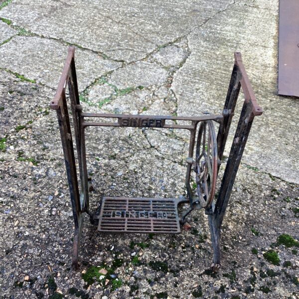 Antique Singer sewing machine base with ornate cast iron detailing.