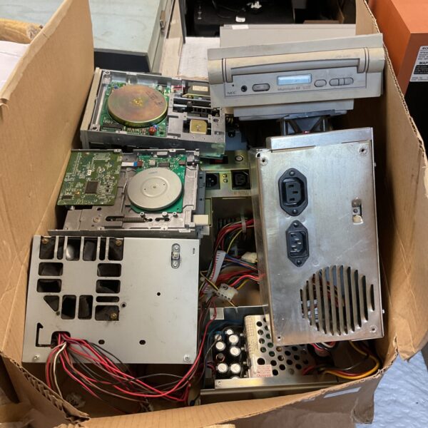 Retro PC spares lot with floppy and CD drives.