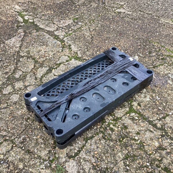 Dark grey plastic garage shelf unit component for storage.