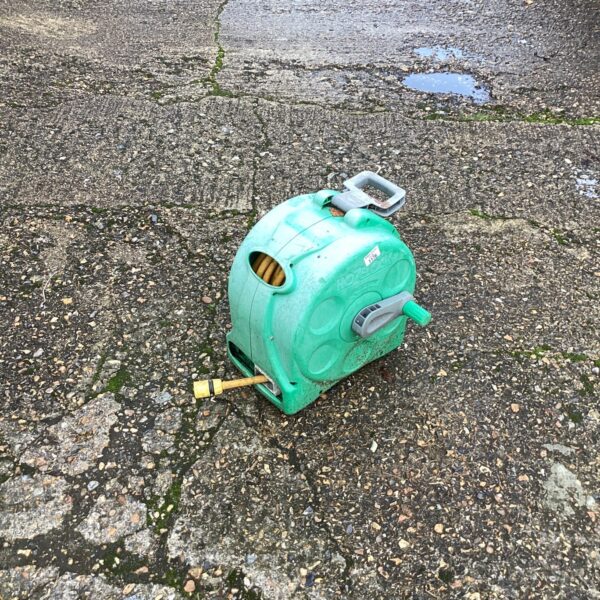 Vintage green Hozelock hose reel for garden hose storage.