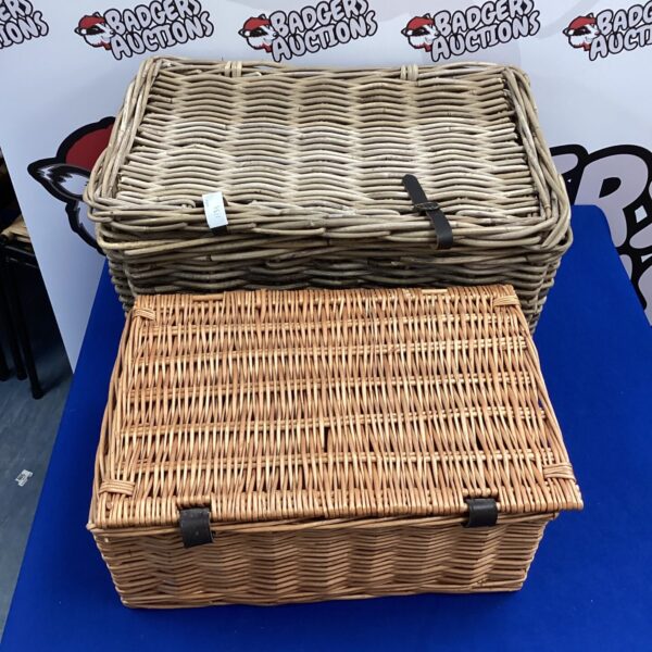 Two vintage wicker baskets with handles, ideal for storage.