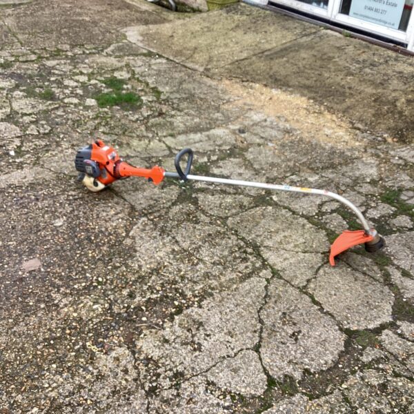 Used Oleo Mac petrol strimmer for garden maintenance.