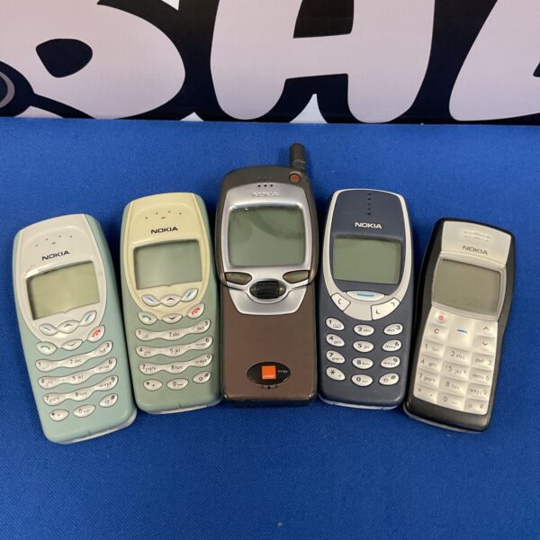 Lot of five vintage Nokia mobile phones on a white background.