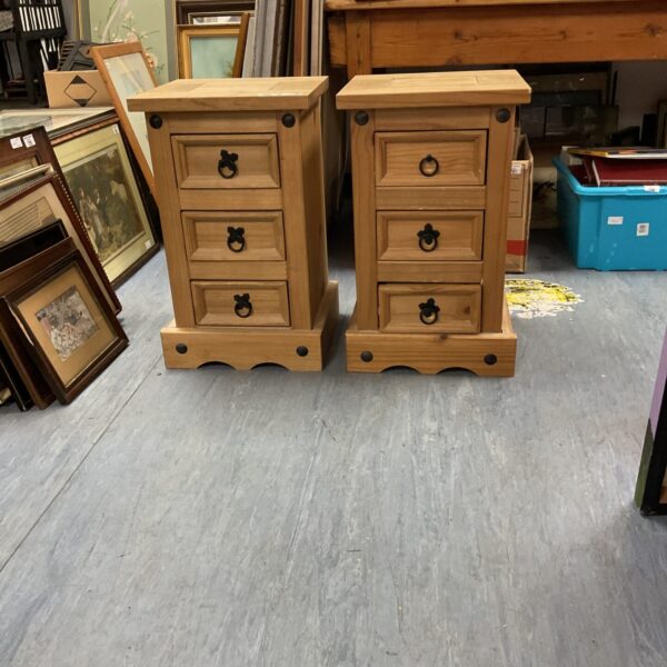 Pair of small chunky pine bedside cabinets with three drawers.