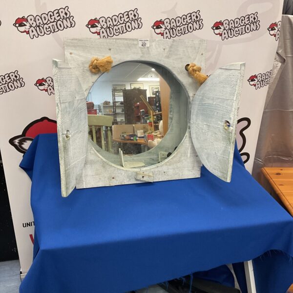 Decorative ship porthole mirror with metal frame.