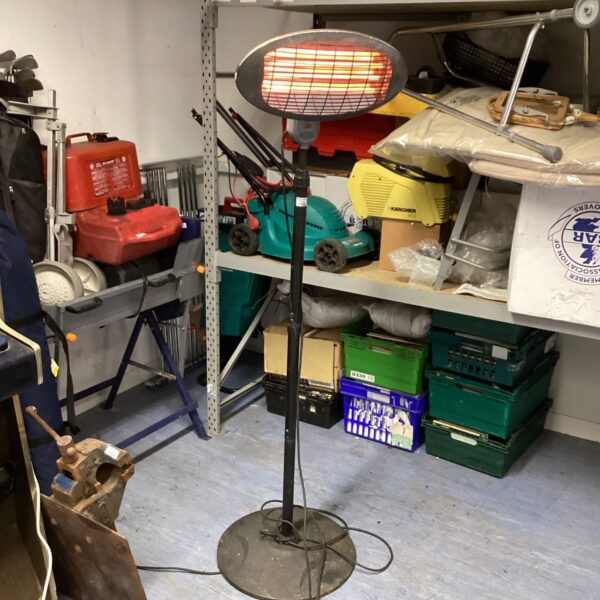 Electric patio heater standing in a garden setting.