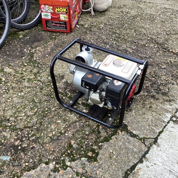 Portable petrol water pump in a garden setting.