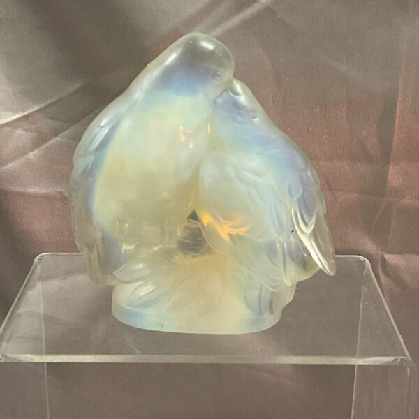 Lalique glass bird sculpture on display, showcasing frosted glass detail.