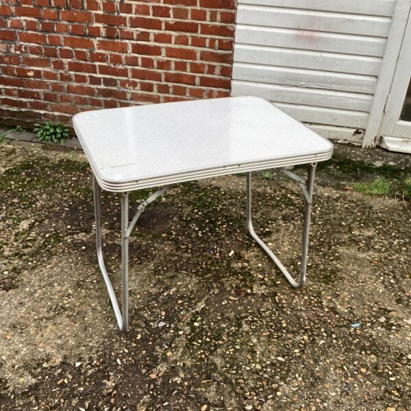 Vintage folding camping table with laminate top and metal frame.