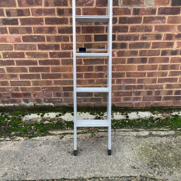 Silver aluminium step ladder against a brick wall.