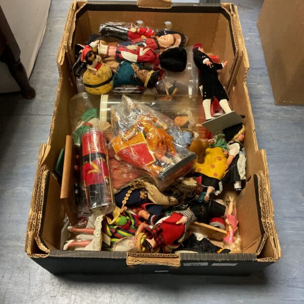 Lot of vintage national costume dolls in a cardboard box.