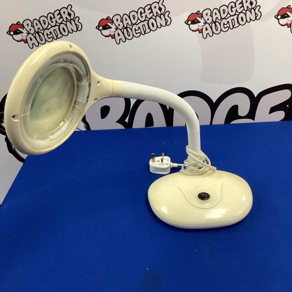 White desk lamp with magnifying glass and flexible arm.