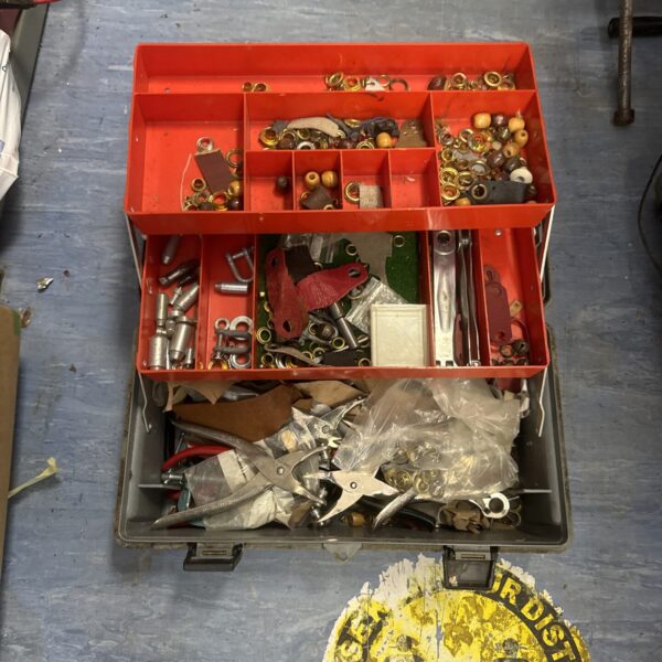 Red plastic toolbox filled with assorted small parts and components.