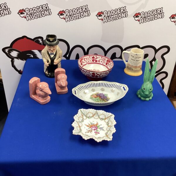 Vintage porcelain figurines and bird bookends on display.