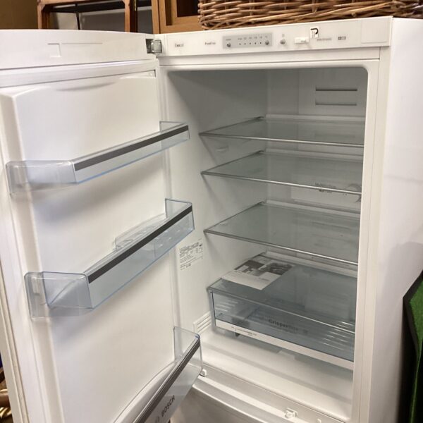 White Bosch fridge freezer with open door and interior shelving visible.