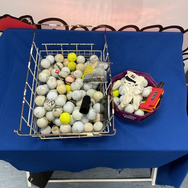 Mixed lot of golf balls, gloves, and accessories for golf.