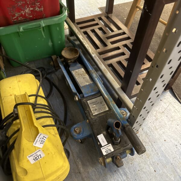 Used hydraulic trolley jack for vehicle lifting in a garage setting.