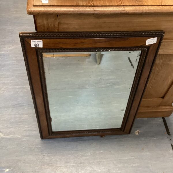 Antique wood-framed mirror with ornate detailing and aged patina.