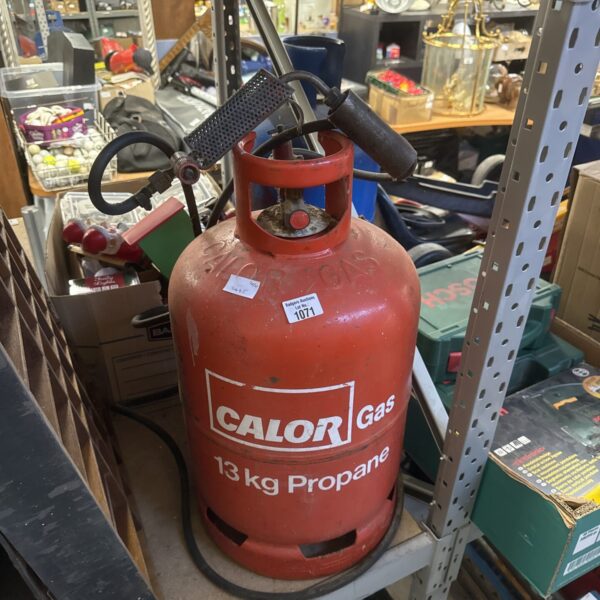 Used Calor gas bottle with torch attachment for outdoor use.