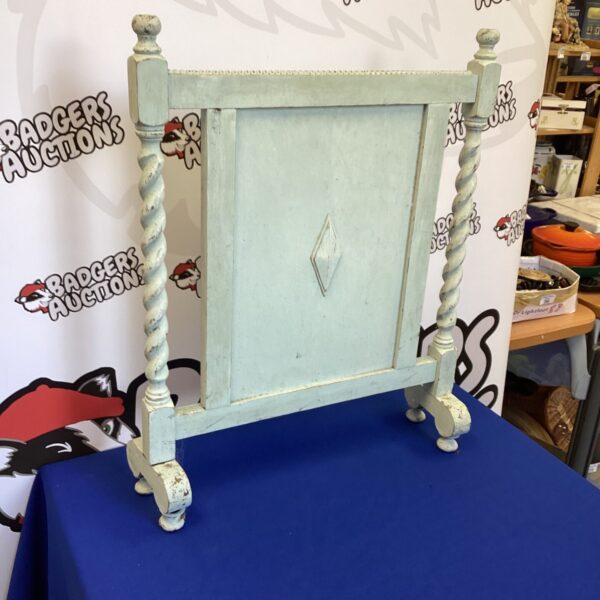 Vintage painted fire screen with ornate wooden posts.