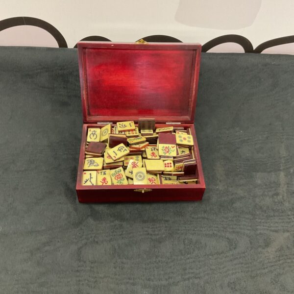 Vintage mahjong set in a red lacquered box with tiles visible.