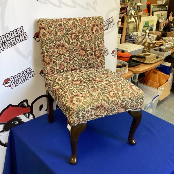 Vintage floral patterned nursery chair with curved back.
