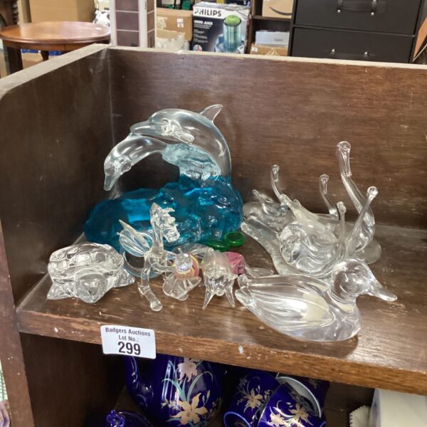 Selection of blue and clear glass dolphin ornaments for home decor.