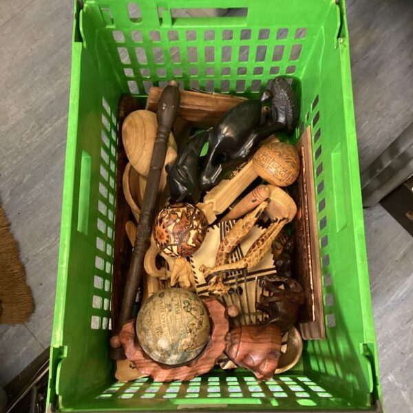 Crate filled with diverse African carved wood art and sculptures.