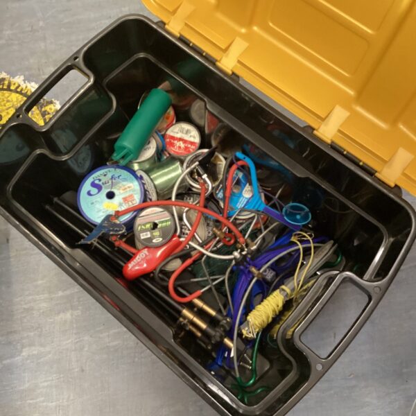 Yellow fishing tackle box filled with line and rod rests.