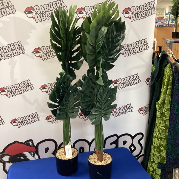 Pair of artificial house plants in black pots.