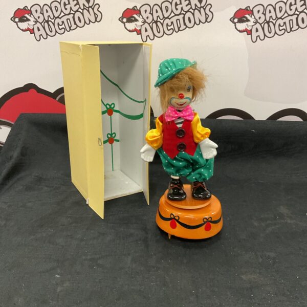 Vintage rotating clown toy with wardrobe, colourful collectible figurine.