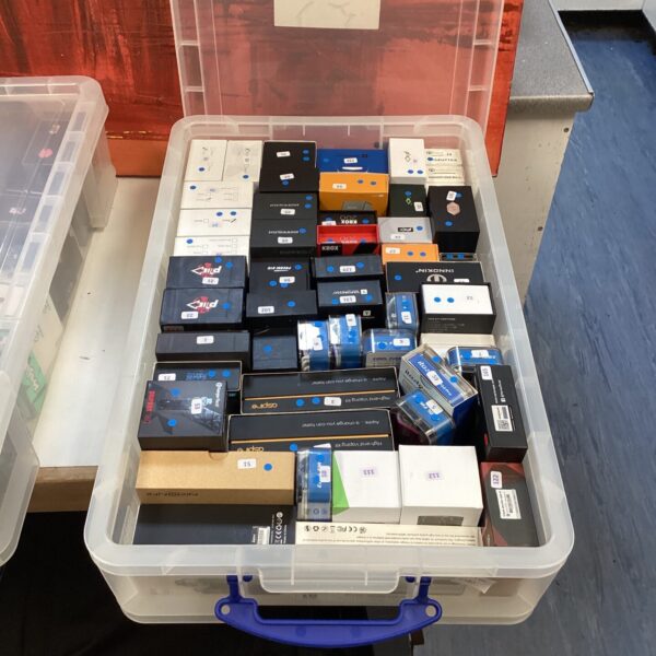 Assorted vaping rigs and mods in a plastic storage box.
