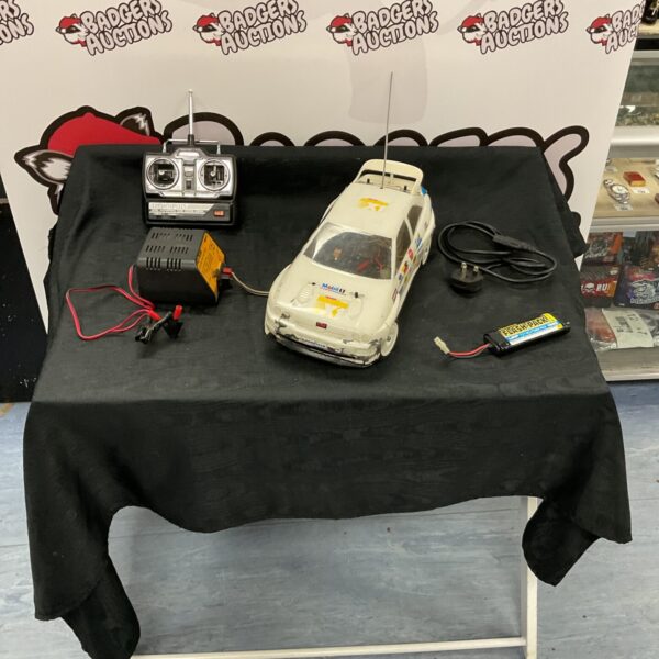 Vintage radio control car with remote control and charger.