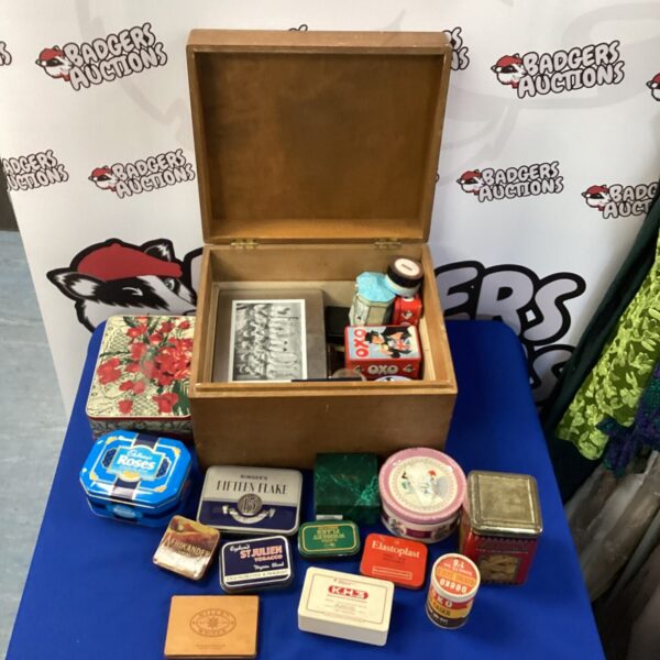 Vintage advertising tin collection in a wooden box.