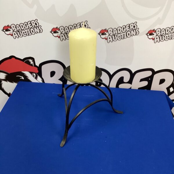 Vintage wrought iron candle holder with a taper candle.
