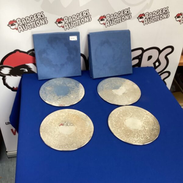 Set of four vintage silverplate coasters with detailed edging.