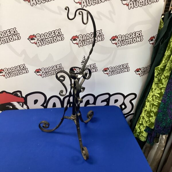 Antique wrought iron candle holder with gothic scrolling details.