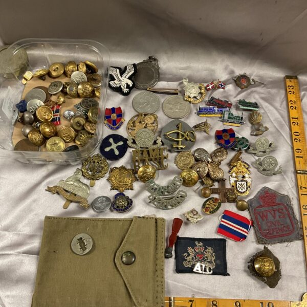Large collection of vintage military badges and buttons for collectors.