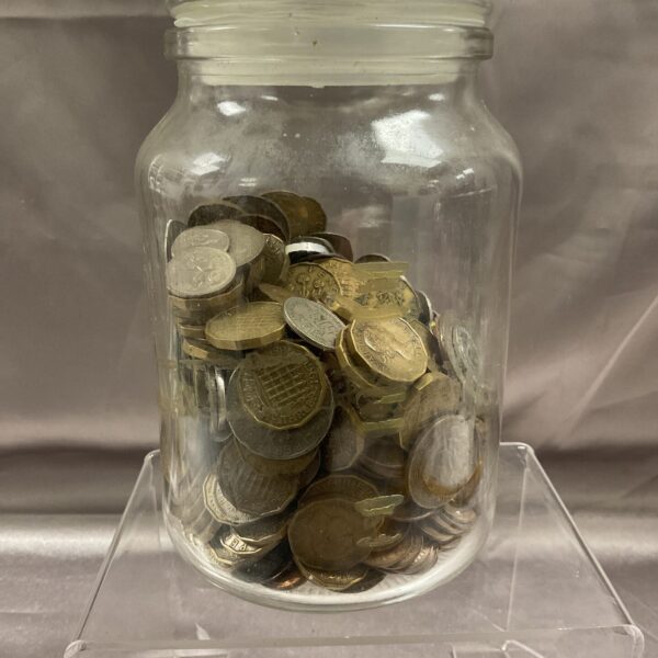 Jar filled with assorted vintage coins for collectors.
